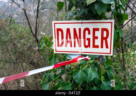 Le signe de danger sur l'arbre avec le rouge et le blanc garder hors bande Banque D'Images