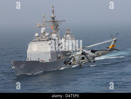 Un SH-60J Seahawk flys par USS Vicksburg lors d'un ravitaillement vertical. Banque D'Images