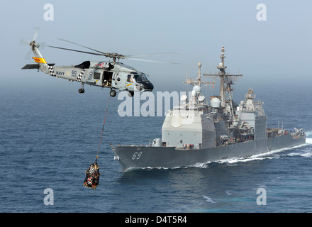 Un SH-60J Seahawk flys par USS Vicksburg lors d'un ravitaillement vertical Banque D'Images