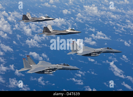 Deux F-15 Eagle et F-22 Raptors volent en formation. Banque D'Images