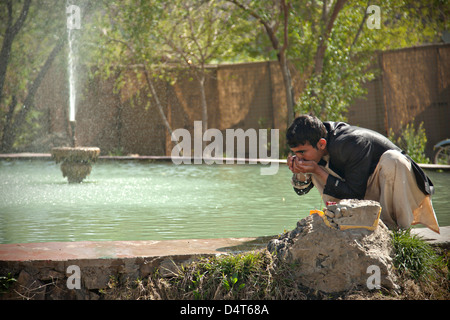 Une police locale afghane candidat prend un verre d'une fontaine publique au cours d'une validation de recrutement le 16 mars 2013 dans la province d'Helmand, en Afghanistan. Banque D'Images