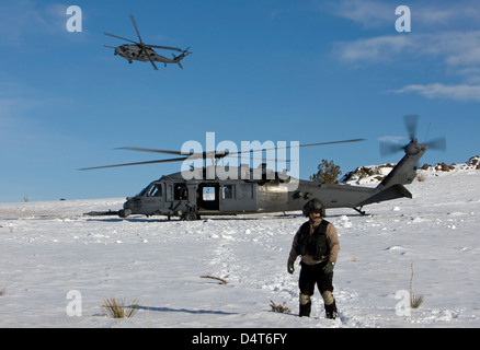 Un membre de l'équipage d'un HH-60G Pave Hawk de l'enquête sur la zone d'atterrissage. Banque D'Images