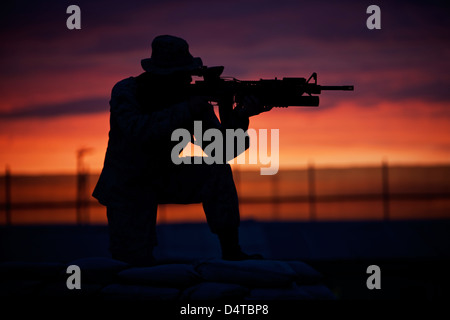 Silhouette d'un Marine américain sur un bunker au coucher du soleil dans le Nord de l'Afghanistan. Banque D'Images