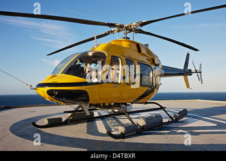 Un hélicoptère Bell 407 sur l'hélisurface de l'utilitaire d'une plate-forme pétrolière. Banque D'Images