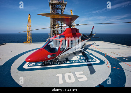 Hélicoptère AgustaWestland AW109E en stationnement sur l'aire d'une plate-forme pétrolière dans le golfe du Mexique. Banque D'Images