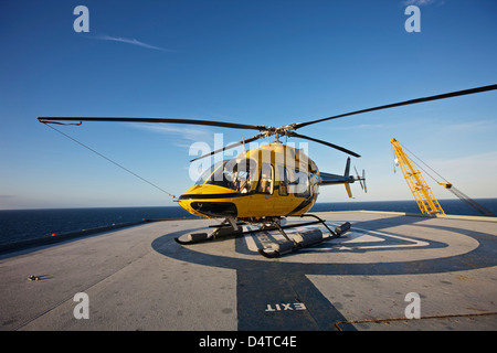 Un hélicoptère Bell 407 sur l'hélisurface de l'utilitaire d'une plate-forme pétrolière. Banque D'Images