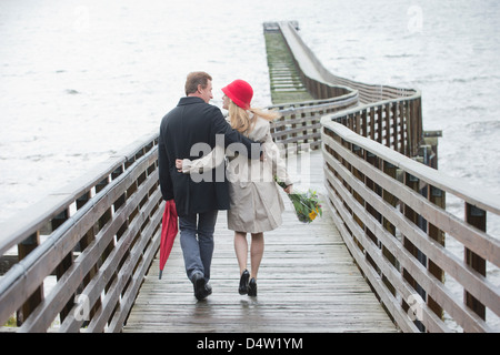 Couple walking on wooden dock Banque D'Images