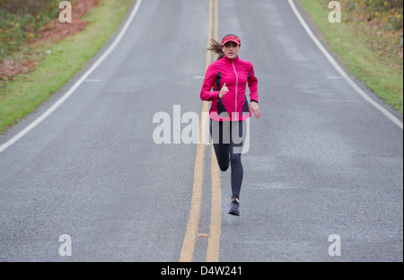 Woman running on rural road Banque D'Images