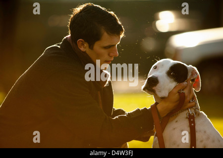 Man petting dog in park Banque D'Images