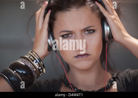 Angry woman wearing headphones Banque D'Images