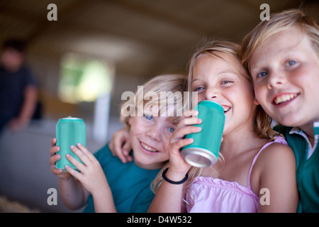 Les enfants de boire de soude dans garage Banque D'Images