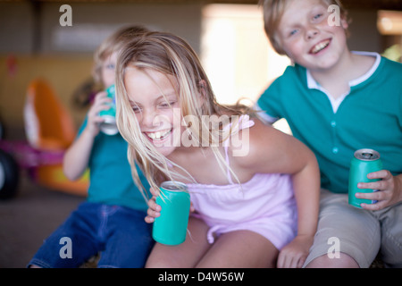 Les enfants de boire de soude dans garage Banque D'Images