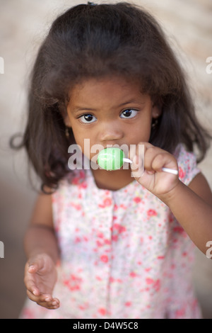 Girl licking lollipop Banque D'Images