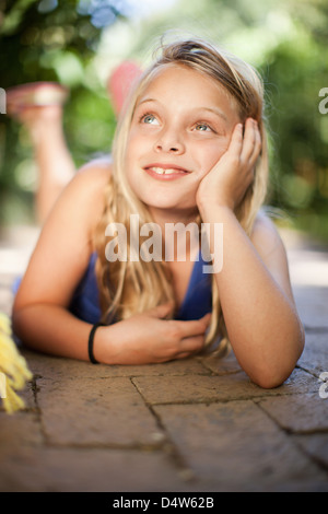 Girl laying on sol extérieur Banque D'Images