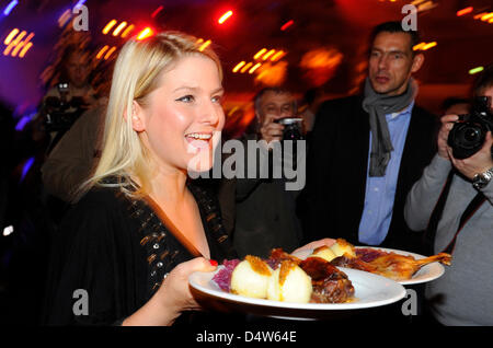 L'actrice Jeanette Biedermann sert des repas pendant le dîner de Noël traditionnel pour les personnes sans domicile à l'hôtel Estrel à Berlin-Neukoelln, Allemagne, le 21 décembre 2009. Les différents repas célébrités à quelques 2,700 personnes à l'organisme de bienfaisance. En dehors de la bière, et oies rôti de couvertures, sacs de couchage et des vêtements chauds ont été remis à l'indigent. Singer Frank Zander, iakonisches "Werk", le Banque D'Images