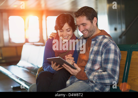 Couple using tablet computer on ferry Banque D'Images