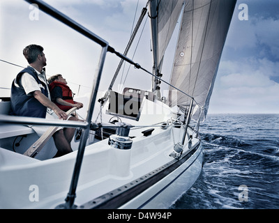 Père et fils en bateau sur l'eau de direction Banque D'Images