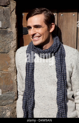 Smiling man wearing scarf outdoors Banque D'Images