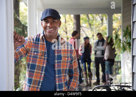 Smiling man standing on porch Banque D'Images