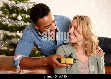 Man giving girlfriend cadeau de Noël Banque D'Images