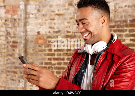 Smiling man using cell phone Banque D'Images
