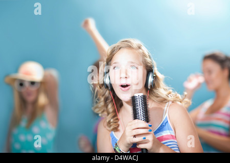 Girl singing into hairbrush Banque D'Images