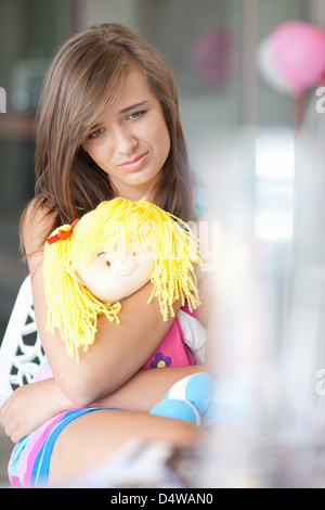 Sad woman hugging doll Banque D'Images