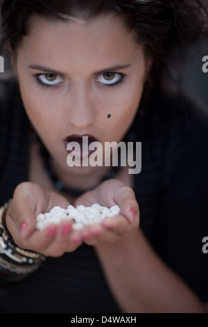 Angry teenage girl holding pills Banque D'Images