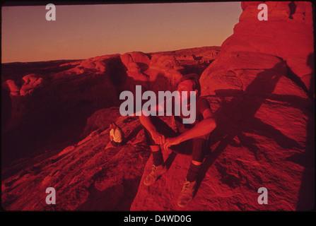 Backpackers Terry Mcgaw et Glen Denny reste dans le soleil couchant à la fin de la piste à Delicate Arch, 05/1972 Banque D'Images