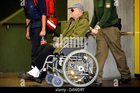 La défenderesse, ancien garde du camp de concentration de Sobibor et citoyen américain, John Demjanjuk, Ivan' accusé de complicité de meurtre, arrive à la cour d'état de Munich dans un fauteuil roulant, Munich, Allemagne, 24 novembre 2010. Le procès contre le criminel nazi présumé John Demjanjuk se poursuivra jusqu'en mars 2011. La cour de district de Munich a déterminé une douzaine d''appointme Banque D'Images