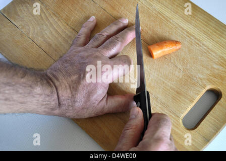 ILLUSTRATION - Un fichier photo datée du 17 septembre 2012 montre un index apparaissant d'avoir été coupé alors que le découpage d'une carotte à Berlin, Allemagne. Photo : Verlag/Steinach - () Banque D'Images