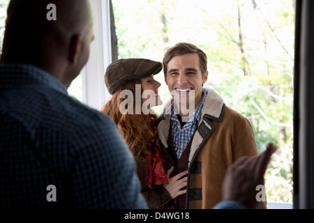 Smiling couple at front door Banque D'Images