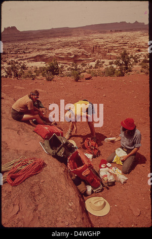 Les Backpackers Terry McGaw, Glen Denny et Steve Miller Tri de la nourriture sur une semaine - long voyage de randonnée à travers le canyon d'eau et le Maze, une région éloignée et accidentée sans sentiers au coeur des Canyonlands, 05/1972 Banque D'Images