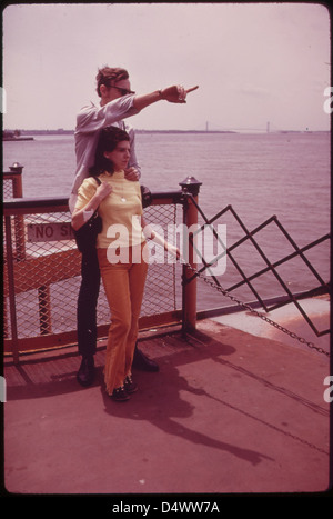Vue de la baie de New York supérieure depuis le ferry de Staten Island en juin 1973. Cette photographie, qui fait partie de DOCUMERICA, capture le port animé et les gratte-ciel environnants de New York. L'image montre le ferry emblématique, offrant un aperçu du trafic maritime quotidien dans la région. Banque D'Images