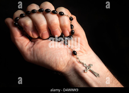 Holding rosary et traverser tout en priant. Banque D'Images