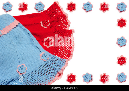Vêtements de bébé tricotés et de fleurs. Rouge, bleu et rose Couleurs. Banque D'Images