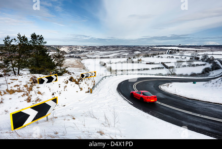 De fortes chutes de neige qu'une voiture voyages sur l'A169 route de Whitby à travers la belle North York Moors National Park près de Goathland. Banque D'Images