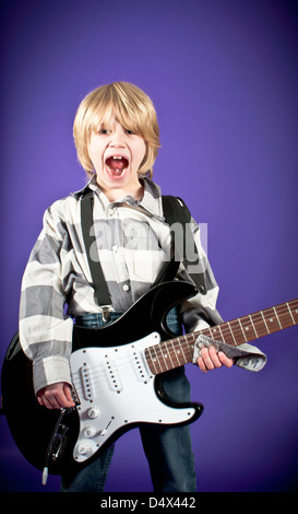 Un jeune garçon jouant de la guitare Banque D'Images