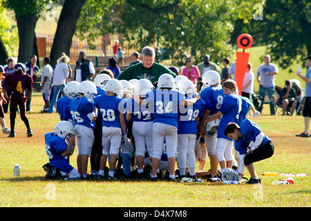 L'âge de 10 jeunes joueurs de football se blottissent autour de coach à l'écoute de ses instructions. St Paul Minnesota MN USA Banque D'Images