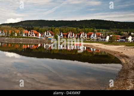 Loisirs de l'établissement resort appelé Nove Lipno avec barrage de Lipno reflétant hills sur le bassin à l'eau en République Tchèque Banque D'Images