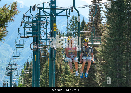 Diggler Mountain Scooters sur l'ascenseur, le purgatoire à Durango Mountain Resort, Durango, Colorado. Banque D'Images