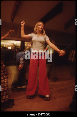 Une photographie des années 1970 montrant des jeunes patins à roulettes à la patinoire Izzy-Dorry à New Ulm, Minnesota, capturant une activité amusante populaire à l'époque avec des pantalons à fond de poule. Banque D'Images