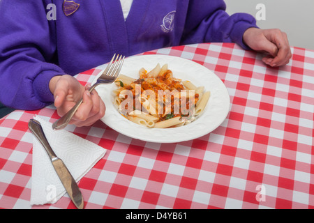 Lycéenne de manger des pâtes à l'école Banque D'Images