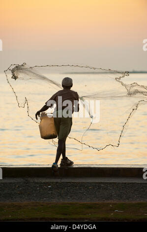 6 mars, 2013 à Cap-Haïtien, Haïti - 6 mars 2013, Cap Haïtien, HAÏTI - Un pêcheur jette son filet de lumière tôt le matin à partir de la rive au Cap Haïtien, Haïti. La pêche d'Haïti se sont effondrées en raison de décennies de surpêche effrénée, un problème de nombreux organismes de développement cherchent à régler en soutenant les efforts de sensibilisation à l'environnement et de subsistance de remplacement en Haïti. (Crédit Image : © David Snyder/ZUMAPRESS.com) Banque D'Images