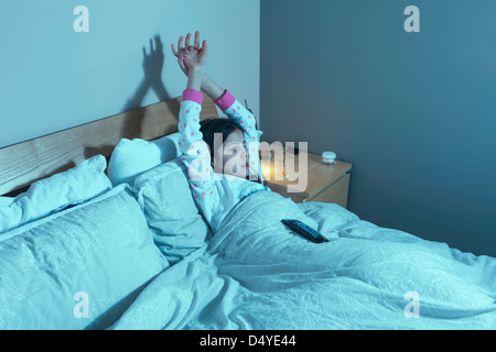 Jeune fille regarde la télévision au lit Banque D'Images