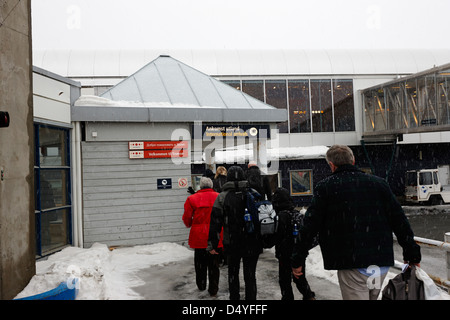 Les touristes arrivant à l'aéroport de Tromso les arrivées internationales dans la neige troms Norvège europe Banque D'Images