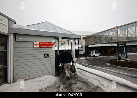 Les touristes arrivant à l'aéroport de Tromso les arrivées internationales dans la neige troms Norvège europe Banque D'Images