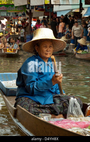En Thaïlande, le marché flottant de Damnoen Saduak. Femme, de collations et de produire des embarcations le long des voies navigables. Banque D'Images