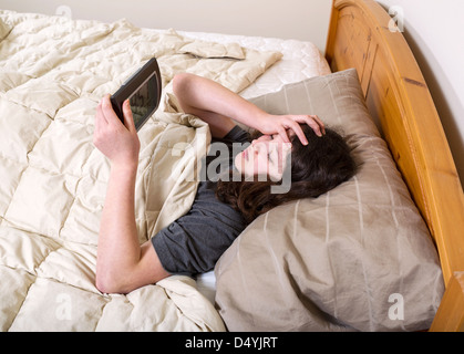 Photo horizontale de jeune fille à la recherche au réveil dans la frustration, tandis que dans le lit Banque D'Images