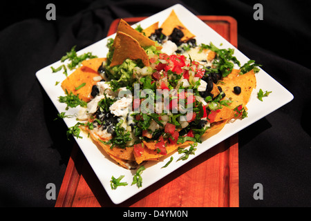 Nachos d'été avec du fromage et du poulet servi sur une plaque blanche Banque D'Images